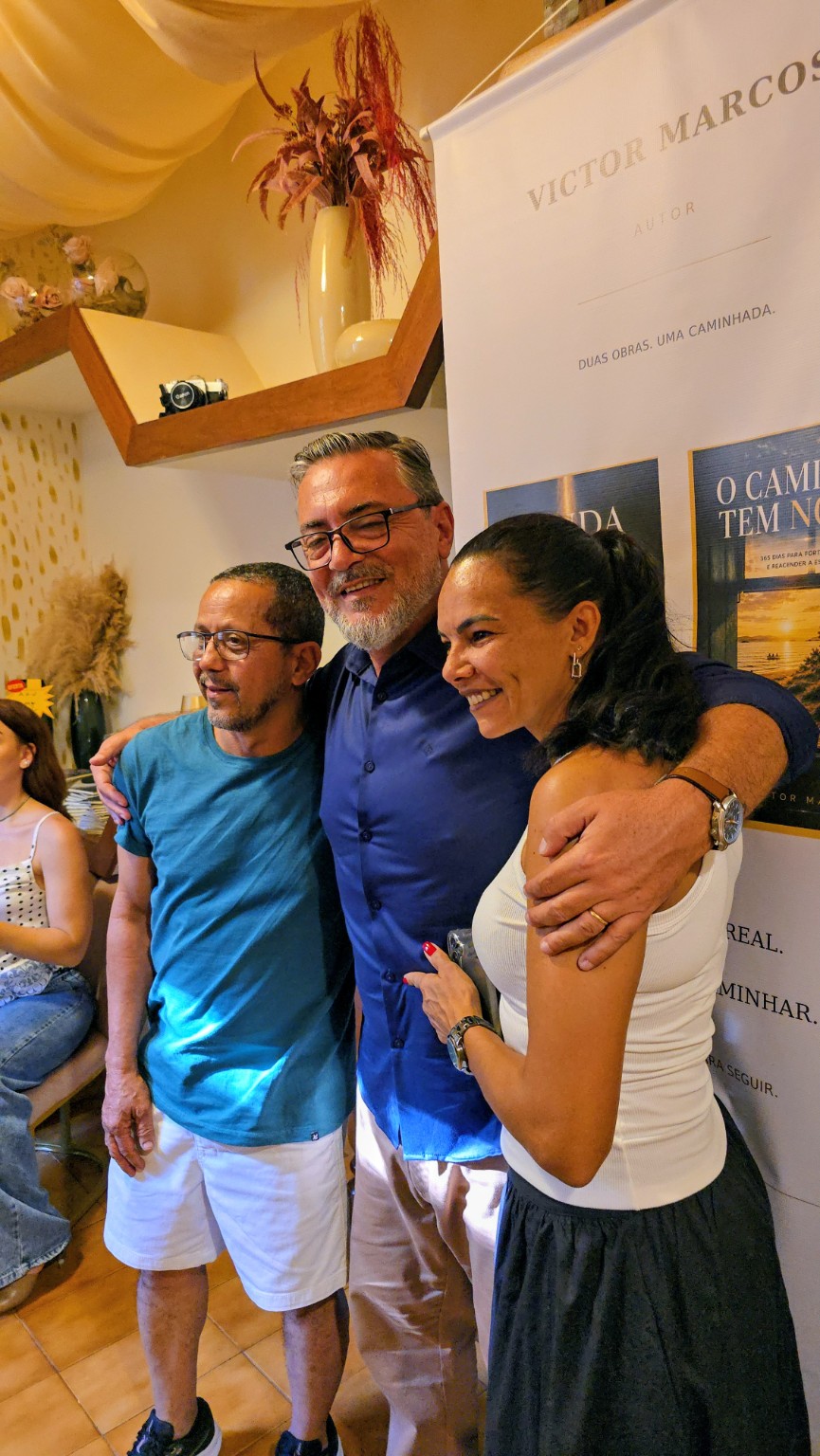 Victor posa ao lado de leitores durante o lançamento.